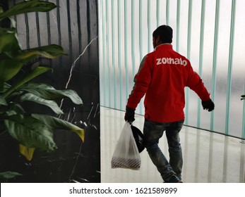 Delhi, India, 2020
Gurgaon Based Zomato, Food Delivery Boy Entering An Office Building During Lunch Time. Online Food Delivery Startup In The Food-tech Space Acquired Uber Eats Competes With Swiggy