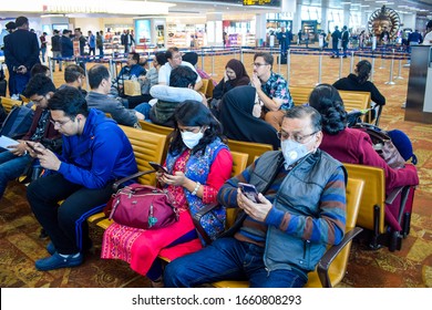 Delhi, India 2020 : Passengers Wesring Face Mask Amid Coronavirus Threat In The Waiting Lobby At The Airport. They Are Working In Their Mobile Phones. Countries Have Imposed International Travel Ban