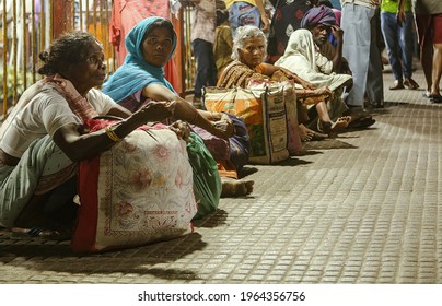 Delhi, India - April 25 2021: Women Migrants Squatting On The Floor With Luggage At Delhi Anand Vihar Bus Stand. Migrant Workers Leaving The City Due To Covid Lockdown. Selective Focus.