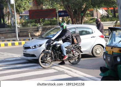 Delhi, India - Jan 2021 , Connaught Place Market After Lockdown. A Swiggy Food Delivery Boy With Order In Traffic 