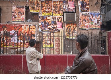 Delhi, India, January 2008. Two Men Watch Bollywood Movie Posters Attached To The Wall.