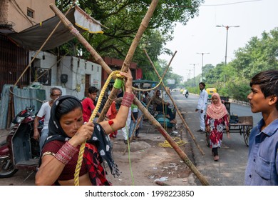 Delhi, India- June 27 2021: Indian Woman Tight A Rope With Pole, Preparing For Tightrope Walking A Street Performance.