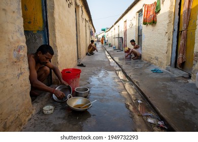 Delhi, India, June 6 2013: Migrant Workers Cleaning His Utensils On Just His Door, A View Of Labor Colony Near Kapas Hera, Delhi Haryana Border. Life In These Rented Houses.