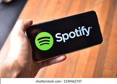 Delhi, india, october 23, 2019: hand holding smartphone and using spotify app, music podcast application, swedish application