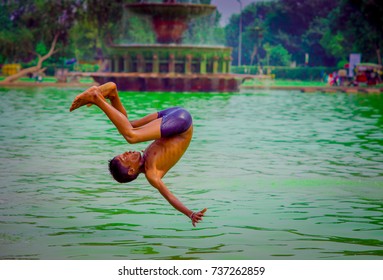 Delhi, India - September 16, 2017: Unidentified Indian Boy Doing A Backflip In The Water, Green Water In A Pond In Delhi, India