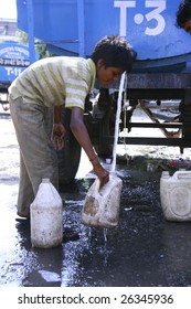 DELHI, INDIA - SEPTEMBER 22 : A Young Boy Collects Drinking Water During Water Shortage On September 22, 2007 In Delhi, India. Delhi Is The Second Most Populous City In India.