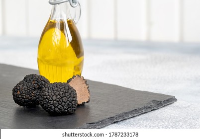 Delicacy Mushroom Black Truffle With Olive Oil Bottle On A Light Background . 