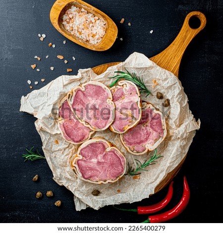 Delicacy sliced beef meatloaf with spiec salt and red pepers on a cutting board. Meat delicacies. Top view and copy space