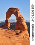 The delicate arch in Arches national park is 52 feet tall, and is a free-standing natural rock arch. It is a well known natural landmark. Behind it can been seen the La Sal mountain range.