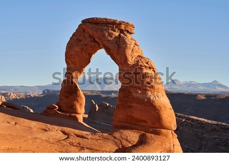 The delicate arch in Arches national park is 52 feet tall, and is a free-standing natural rock arch. It is a well known natural landmark. Behind it can been seen the La Sal mountain range.