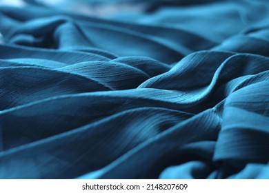 Delicate background texture: elegant soft blue silk fabric. Azure tissue clothing, aquamarine luxurious dress textile with folds. Chiffon cloth, cyan 3d abstract sea waves