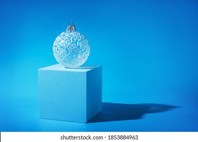 delicate beautiful white Christmas tree ball blue background 