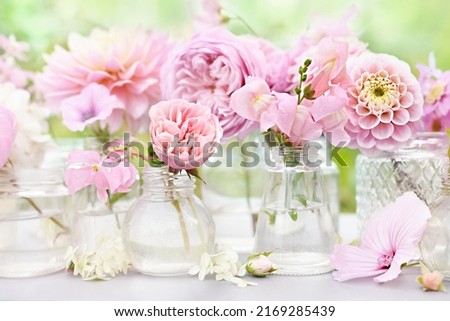 Delicate blooming light pink flowers in bottles, summer blossoming floral festive background, bouquets floral card, selective focus, shallow DOF