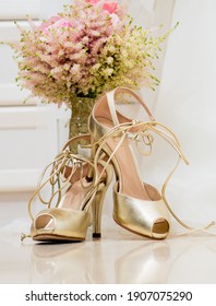Delicate bridal bouquet in the hands of the bride and bridal shoes. Beautiful wedding look