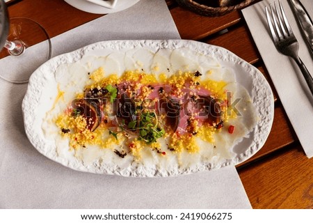 Delicate codfish carpaccio served with fig slices, microgreens and piquant citrus sauce..