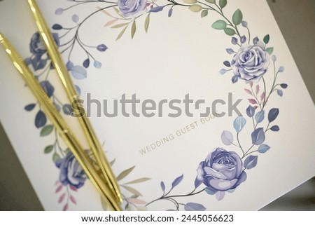 Delicate floral wedding guest book with golden pens