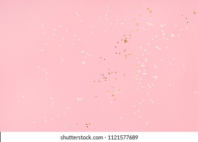 Delicate golden glitter circles on pink background. Flat lay style