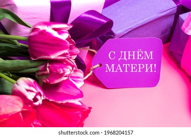 Delicate pink tulips and gift boxes with a tag with the inscription in Russian Happy Mother's Day - Powered by Shutterstock