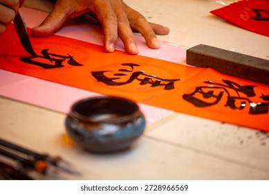 the delicate process of creating Spring Couplets through Chinese calligraphy, the Chinese words means happy lunar new year  