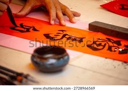 the delicate process of creating Spring Couplets through Chinese calligraphy, the Chinese words means happy lunar new year  