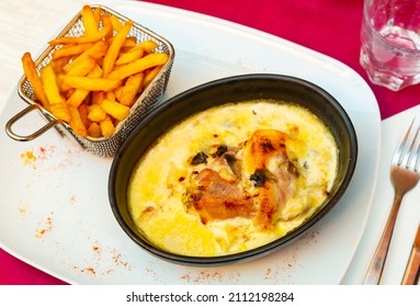 Delicate Savoyard chicken escalope baked with bacon and zucchini in creamy sauce with dry white wine and emmental cheese, served with crispy fries..