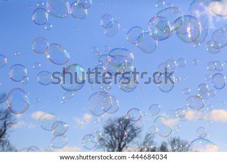 Delicate soap bubbles floating in a blue sky