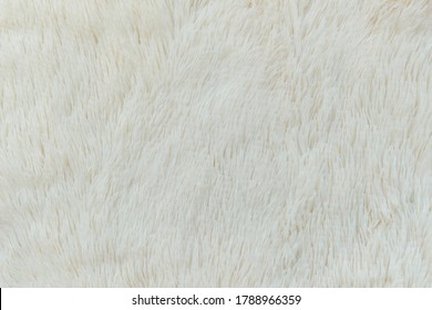 delicate soft background of plush fabric folds on white background. Copy space. Flat lay. loose folds on the fabric of faux fur of lilac color. Details of warm winter clothes