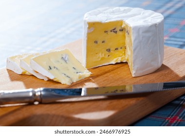 Delicate soft blue cheese served on wooden cutting board .. - Powered by Shutterstock