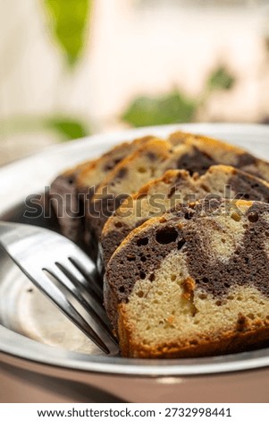 The delicate texture of the marble pound cake slices, interwoven with chocolate, presents an enticing visual appeal.