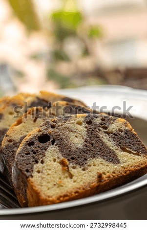 The delicate texture of the marble pound cake slices, interwoven with chocolate, presents an enticing visual appeal.