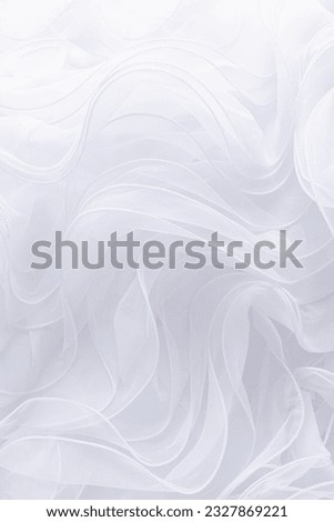 Delicate texture of silk fabric with flowing waves of white silk. Vertical wedding background. Background image for decor