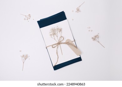 Delicate wedding invitation mock up, greeting card, postcard template decorated with name tag made of kraft brown paper, dry flowers and stylish kraft ribbon, rope - Powered by Shutterstock