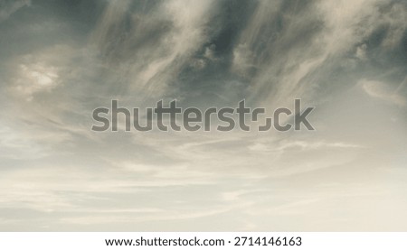 Delicate wispy multicolor clouds with a blue sky behind indicating a change in the weather.blue sky background with white clouds . Beautiful blue sky with a few clouds and a pinkish hue. 
