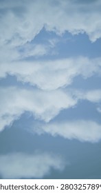 Delicate wispy and puffy white clouds scattered over soft light blue sky, beautiful natural cloudscape with soft edges and gentle shapes. Calm and airy mood, bright daylight, subtle depth, peaceful atmospheric background, perfect for nature and weather themes.