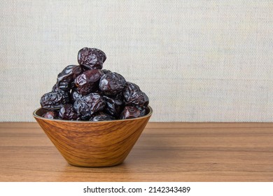 Delicious ajwa dates (Prophet dates), Much sought after during the month of Ramadan as a dish for breaking the fast, ramadhan kareem, in wooden bowls, empty space, copy space.