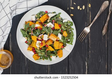 Delicious Autumn Salad With Pumkin Or Squash, Arugula And Feta Cheese, Top View. Comfort Healthy Food.