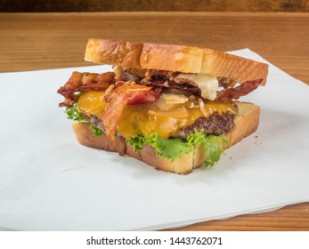 Delicious Bacon Cheeseburger With Cheddar Cheese Served On Texas Toast. An Unhealthy Food For Dinner.