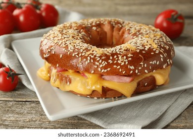 Delicious bagel with ham and cheese on wooden table - Shutterstock ID 2368692491