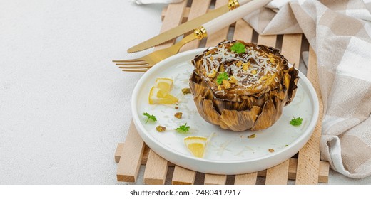 Delicious baked artichoke with parmesan cheese and pistachio. Olive oil, garlic, parsley and lemon. White wooden background, ready to eat vegan food, banner format - Powered by Shutterstock