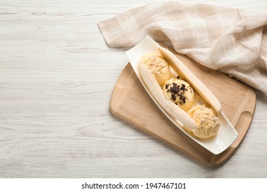 Delicious Banana Split Ice Cream With Toppings On White Wooden Table, Top View. Space For Text