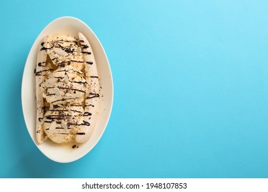 Delicious Banana Split Ice Cream With Toppings On Light Blue Background, Top View. Space For Text