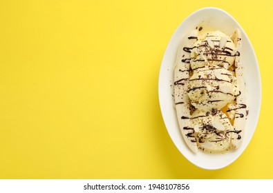 Delicious Banana Split Ice Cream With Toppings On Yellow Background, Top View. Space For Text