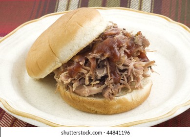 A Delicious Barbecue Sandwich Piled High With Pulled Pork Roast And Barbecue Sauce On Top, Served On A Plate, Horizontal With Copy Space, Selective Focus