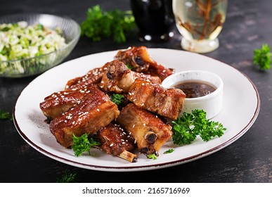 Delicious Barbecued Spare Ribs On Plate On Dark Background. Tasty Bbq Meat.