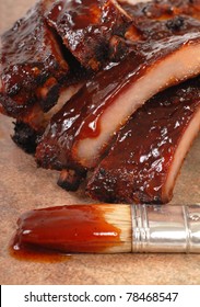 Delicious BBQ Baby-back Ribs With Tangy Sauce And A Sauce Brush With Focus On The Sauce Drip