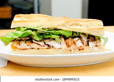 A Delicious Bbq Chicken Sandwich On French Bread With Tomatoes And Lettuce