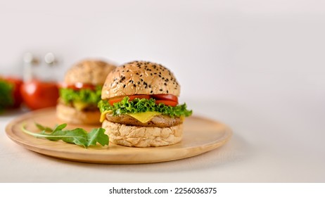 Delicious beef burgers on wooden plate on white table and background. close-up image. Tasty fast food concept - Shutterstock ID 2256036375