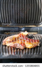 Delicious Beef Meat With Smoke Grilled In Cramped Kitchen