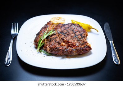 Delicious Beef Steak Cooked On Grill For Dinner In American Meat Restaurant,served On White Ceramic Plate With Fork And Knife For Eating.Download Royalty Free Curated Images Collection With Foods