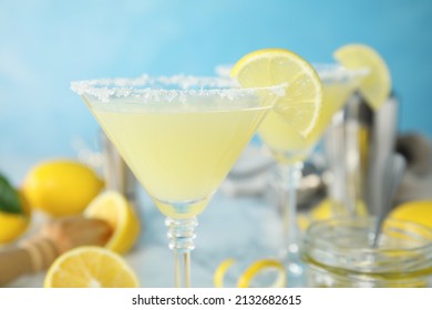 Delicious bee's knees cocktail on table against light blue background, closeup